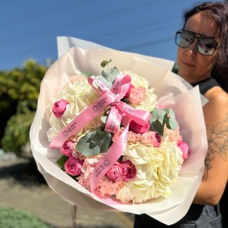 Ніжний мікс гортензії та піоновидної троянди – букет із 3 гортензій, 1 гілки евкаліпта, 9 кущових троянд і 8 троянд Місті Баблз у білій і рожевій упаковці з рожевим декором