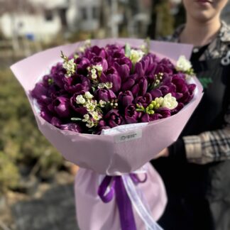 Букет із 71 квітки: фіолетові тюльпани, фрезія та хамелаціум, в оформленні.