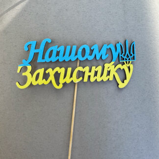 Топпер "Нашому Захиснику" для торта чи квіткової композиції – шляхетна прикраса для особливого свята, присвяченого мужньому герою.